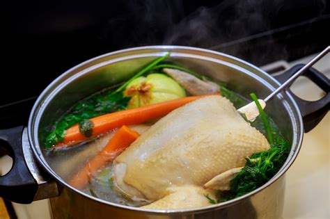 Olla con caldo de gallina hirviendo