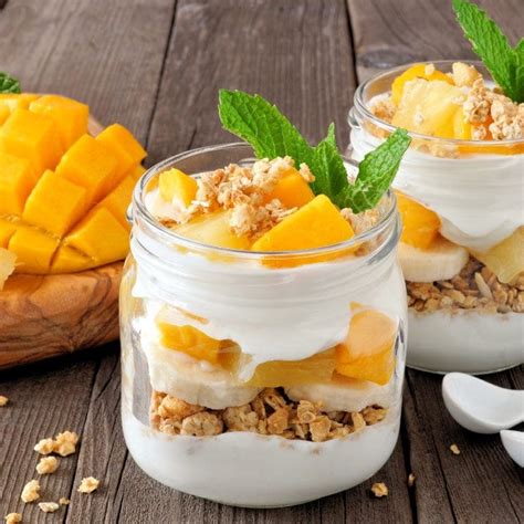 Postre de mango servido en copas decorado con trozos de fruta fresca