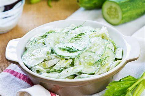 Ensalada fresca de pepino y yogurt servida junto a croquetas doradas