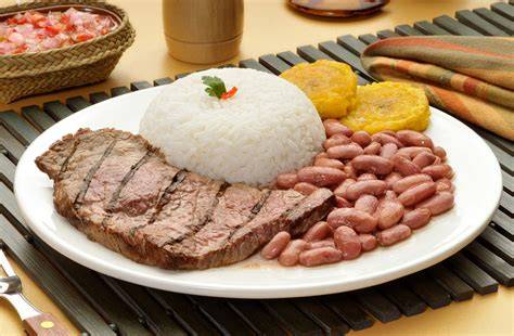 Plato servido de arroz con menestra y carne asada