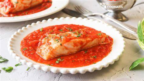 Plato de bacalao con salsa de tomate servido con perejil fresco