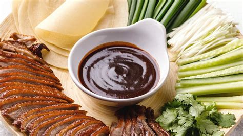 Ingredientes básicos sobre una mesa de madera: salsa hoisin, jengibre, especias y soja