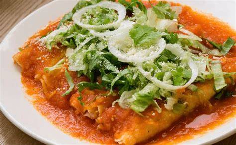 Plato de enchiladas saludables hechas con hojas de repollo y salsa roja