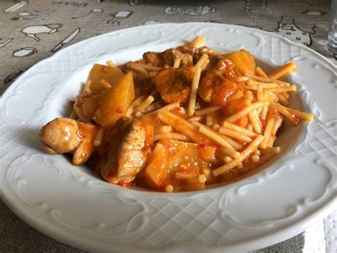 Guiso de fideos con carne de cerdo servido en un plato