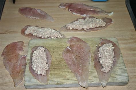Filetes de pollo rellenos preparados sobre papel de aluminio antes de hornear