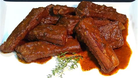 costillas de cerdo troceadas crudas con adobo en una fuente de horno