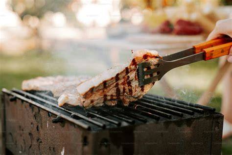 Persona asando carne en una parrilla tradicional