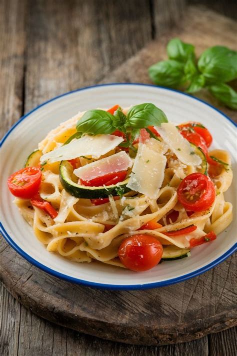 Plato de pasta con verduras frescas y salsa cremosa de queso