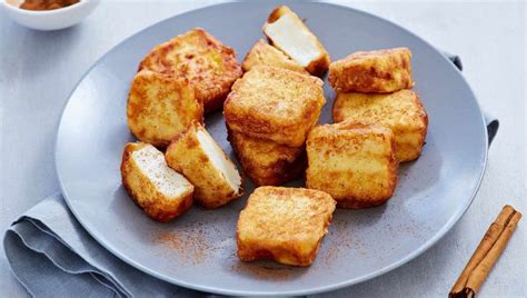 Leche frita recién frita y espolvoreada con azúcar y canela, lista para servir