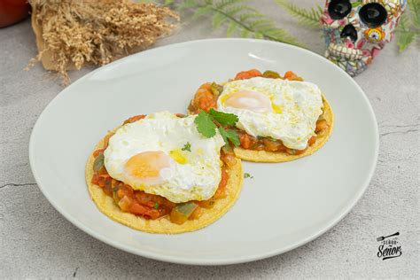 plato de huevos rancheros sobre tortilla frita
