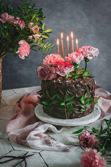 tarta de cumpleaños elegante decorada con flores naturales y velas