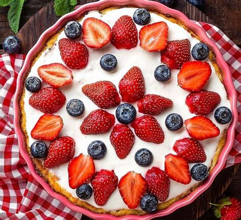 tarta decorada artísticamente con fresas, kiwis y arándanos frescos