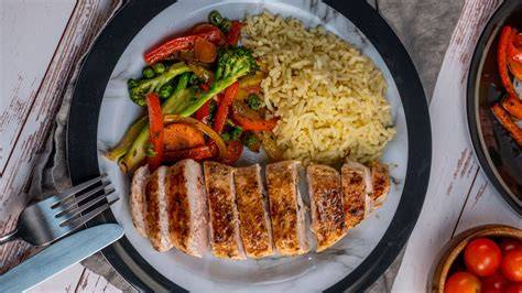 Pollo glaseado servido con guarnición de arroz y verduras