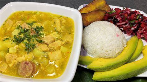 Sopa de arroz con mondongo servida en un tazón, acompañada de aguacate y banano