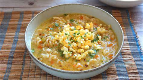 Mesa con ingredientes frescos para sopa de arroz con mondongo: mondongo, verduras variadas, arroz y especias