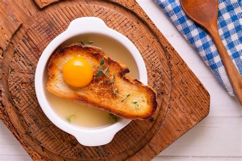Plato de sopa de tomillo con huevo escalfado y pan tostado