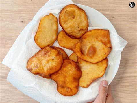 Donas recién fritas escurriendo sobre papel absorbente