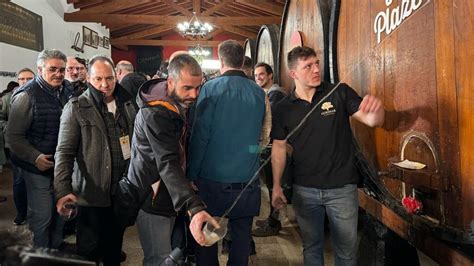 Gente sirviéndose sidra directamente de la kupela (txotx)
