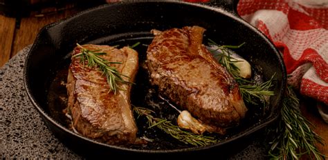 Ribeye a la parrilla con mantequilla de romero y guarniciones