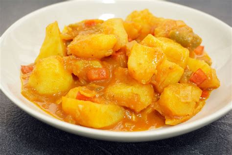 Plato de patatas guisadas tradicionales con cebolla y perejil