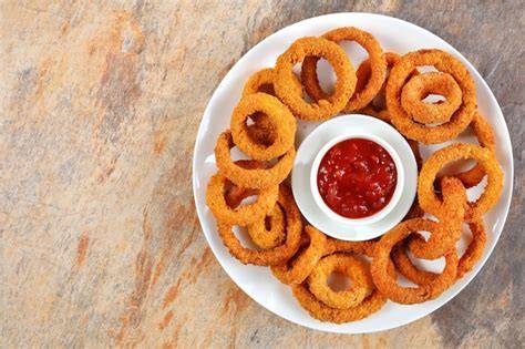 Aros de cebolla servidos con salsa barbacoa y ketchup