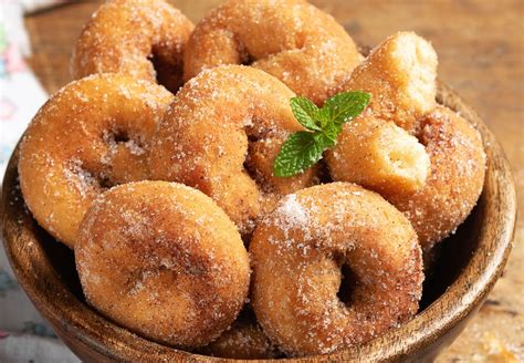 Rosquillas caseras recién fritas, espolvoreadas con azúcar, sobre papel absorbente