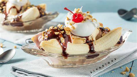 Imagen de un banana split tradicional con helado, nata montada y frutas