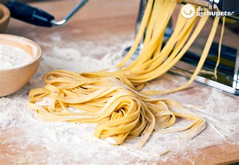 Pasta fresca casera siendo cortada con máquina