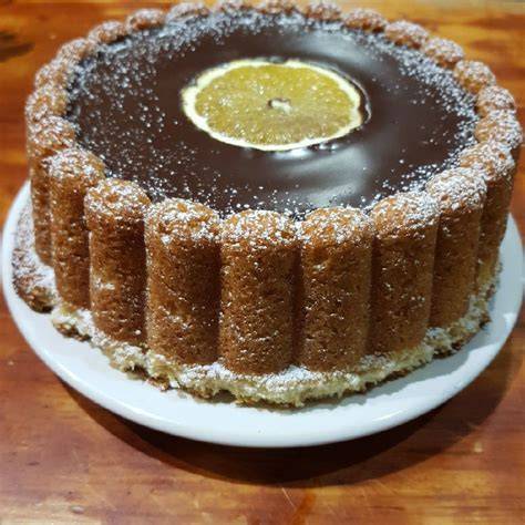 Ganache de chocolate cubriendo la tarta de naranja y almendra
