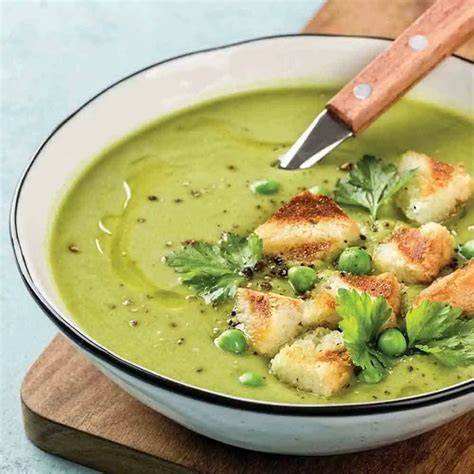 Crema de brócoli servida en un tazón con crutones y un chorrito de aceite de oliva