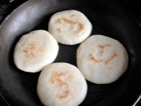 Arepas dorándose en una sartén