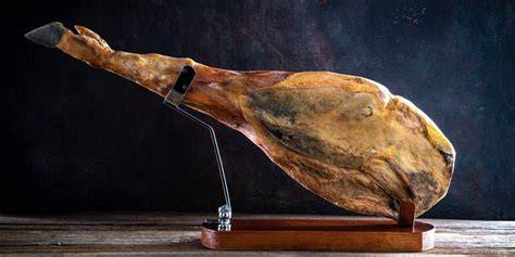 Primer plano de la pezuña de un jamón colocada en el soporte de una tabla jamonera