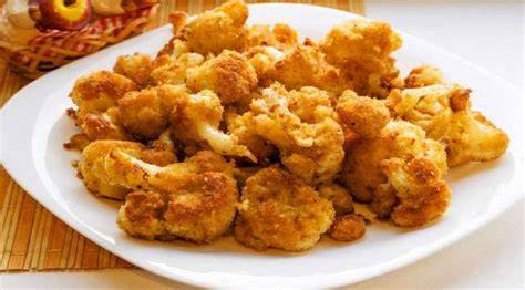 Coliflor rebozada dorada y crujiente en un plato