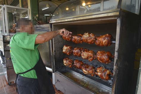 Asadero de pollos rotatorio en un mercado