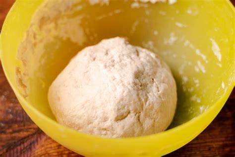 Masa de pizza levándose en un bol