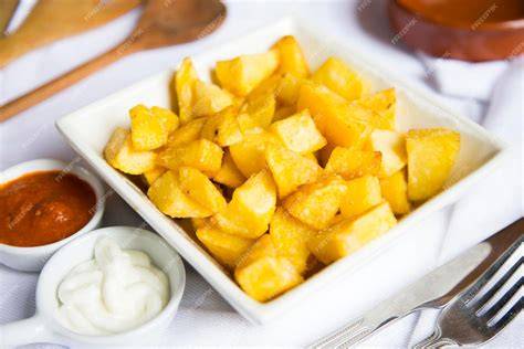 Papas cortadas en cubos salteándose en una sartén