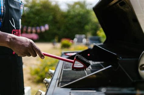 Persona limpiando una parrilla de barbacoa con productos naturales