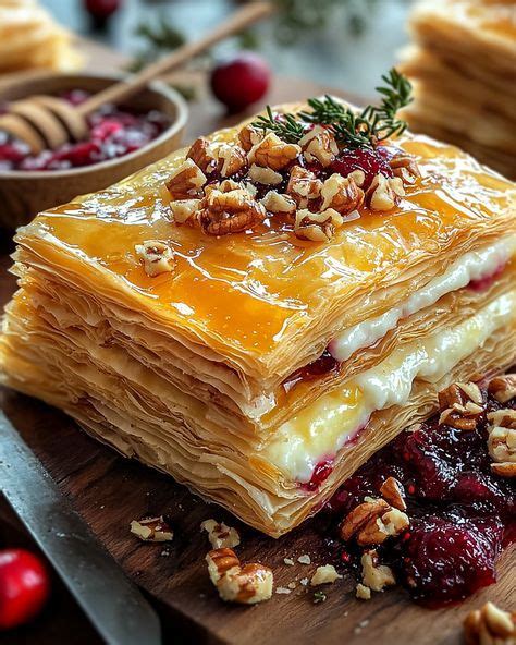 Capas de masa filo untadas con mantequilla y relleno de frutos secos en un molde