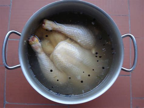 Varias piezas de pollo cocido en una olla con salsa y patatas.