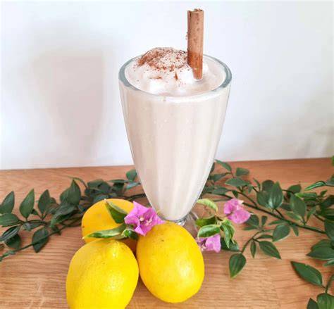vaso de leche merengada con canela y rodaja de limón