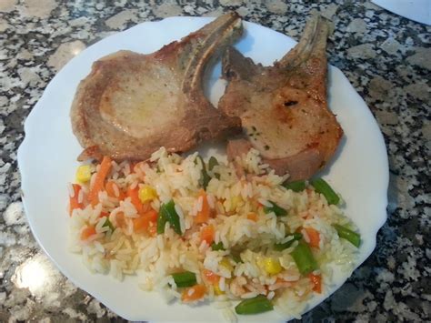 Plato de arroz frito con chuleta ahumada, vegetales y aguacate