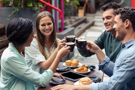 Fachada de una cafetería-pastelería con gente disfrutando en la terraza