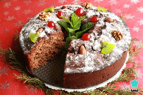 Torta negra navideña venezolana con glaseado blanco y cerezas