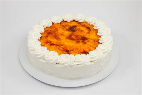 Tarta de piononos terminada con copetes de crema y azúcar quemado