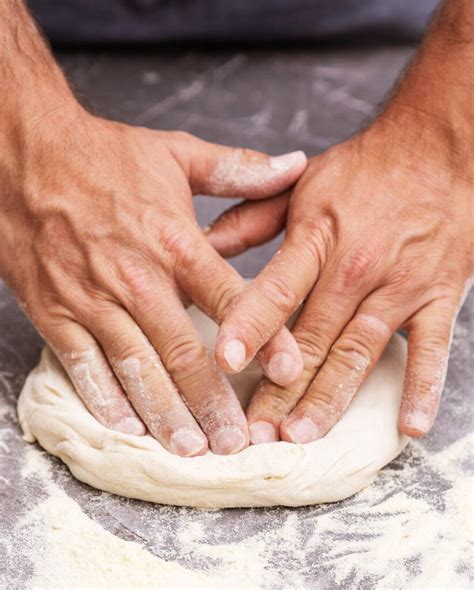 Manos estirando masa de pizza