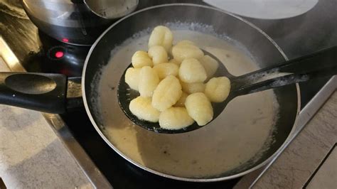 Ñoquis salteándose en una sartén con salsa