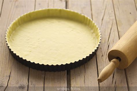 Masa de tarta en el molde con papel de horno y garbanzos