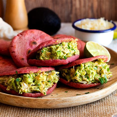 Plato de arepas de remolacha rellenas y acompañadas