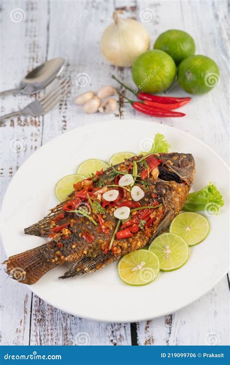 Tilapia frita dorada en un plato con limón