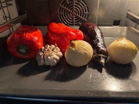 Pimientos y tomates asándose en el horno